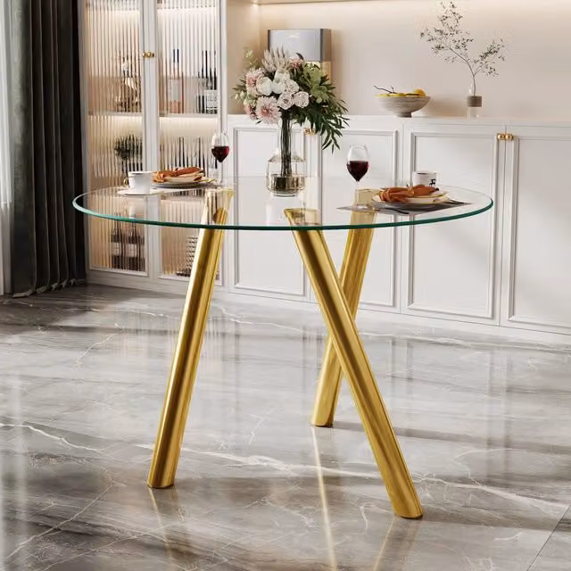 Tavolo da pranzo rotondo Mivray con piano in vetro trasparente e gambe in metallo dorato con struttura a X